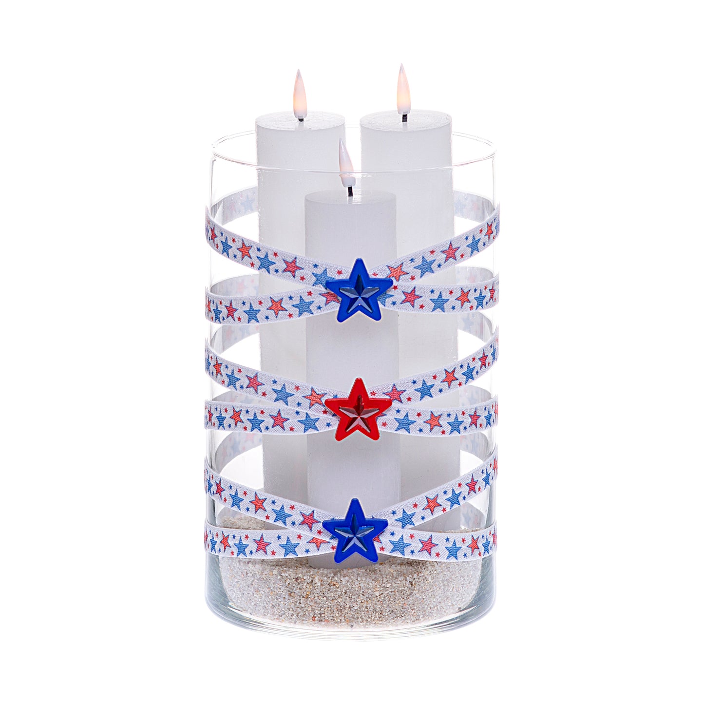 Front of Glass Wrappings 6" x 10" cylinder wrapped in white elastic with red and blue stars, adorned with red and blue gem stars on 1-1/2" red and blue star buttons. It is filled with 3 white candles.