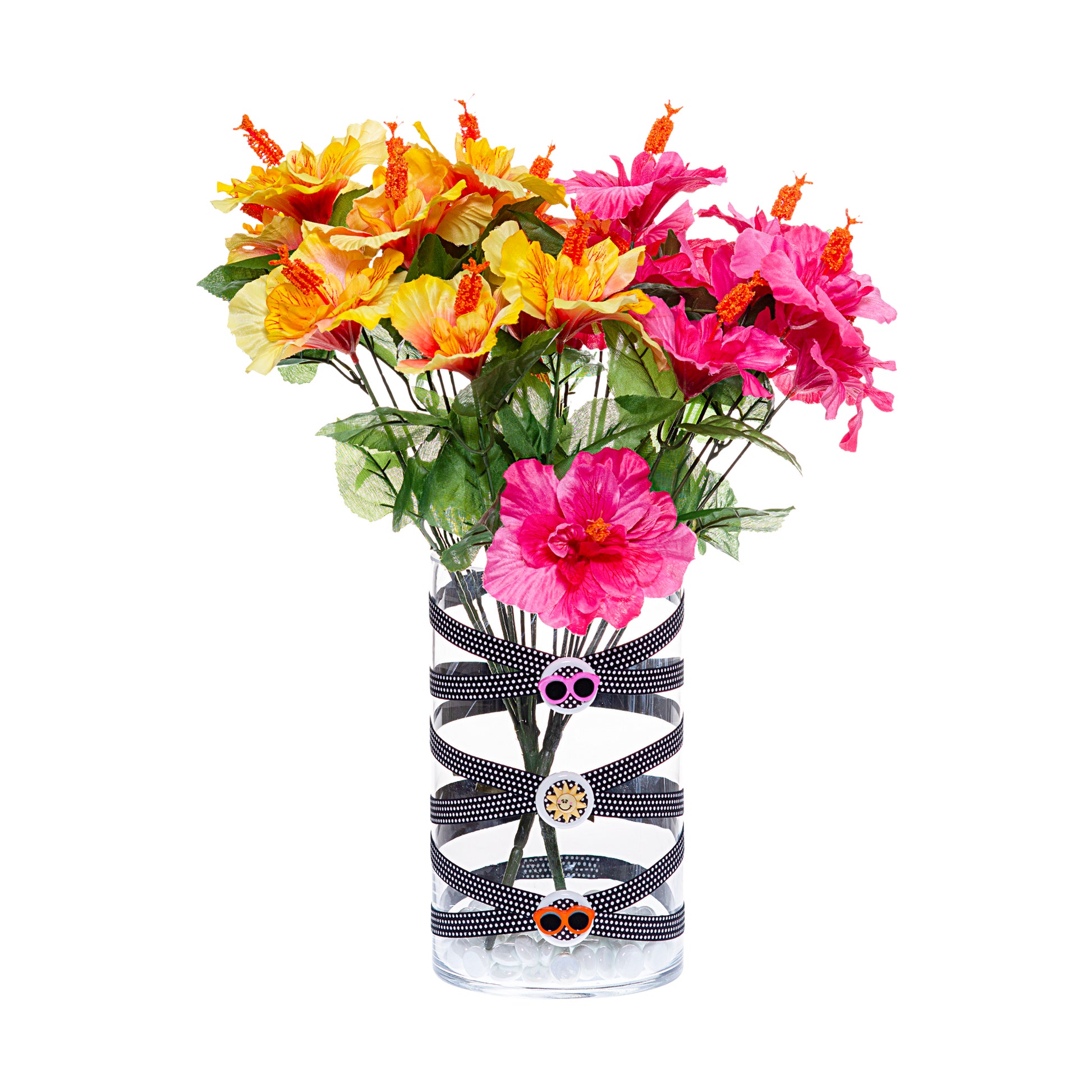 Front of Glass Wrappings 6" x 10" cylinder wrapped with black and white polka dot elastic, decorated with five pairs of colorful sunglasses and a smiley sun. It is filled with tropical flowers.